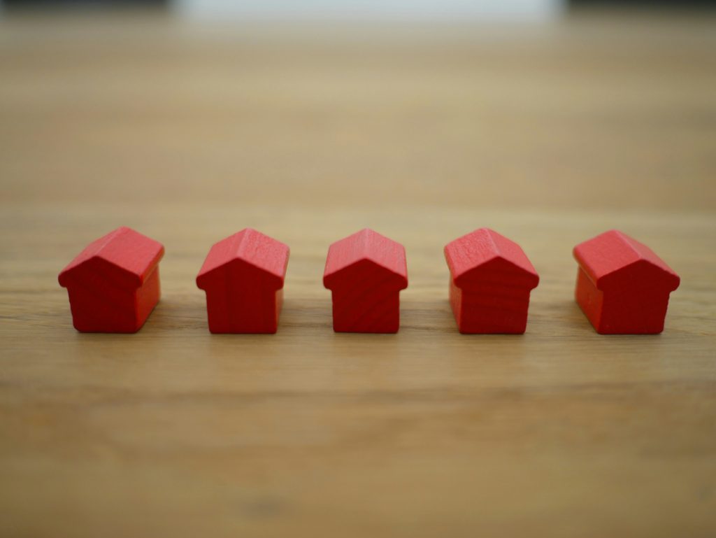 Many red houses in a row showing real estate inventory is building. Photo courtesy of Tierra Mallorca on Unsplash.